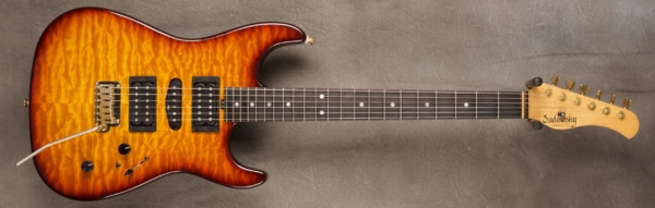 MODEL: Chuck Loeb's S-style,
SERIAL: #6061 (built 2012),
FINISH: Dark cherry burst,
BODY: Swamp ash,
WEIGHT: 6.58 lbs,
NECK: Maple with thin matte nitro finish,
FINGERBOARD: Ebony with mother of pearl dots, 12″ radius, 1 5/8″ nut width,
PICKGUARD: none,
HARDWARE: Gold,
PICKUPS: Sadowsky H-S-H,
PREAMP: Sadowsky preamp with mid/mid-gain boost and custom Chuck Loeb wiring