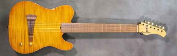 MODEL: Standard Electric Nylon,
SERIAL: #6165,
FINISH: Caramel Burst,
BODY: Chambered Okoume with Flame Maple Top,
WEIGHT: 5.76 lbs,
NECK: Maple with thin matte nitro finish,
FINGERBOARD: Morado, 12″ radius, 1 7/8″ nut width,
PICKGUARD: None,
HARDWARE: Gold,
PICKUPS: Barbera under-saddle,
PREAMP: Sadowsky buffer preamp