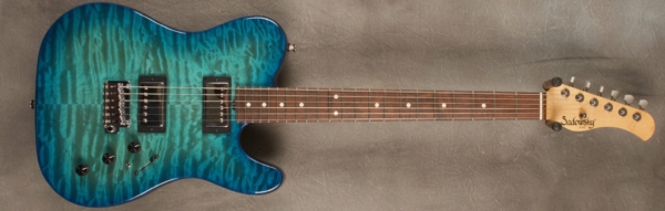 MODEL: Standard T-style,
SERIAL: #7341,
FINISH: Bora Blue Burst with Quilted Maple Top,
BODY: Alder,
WEIGHT: 6.88 lbs,
NECK: Maple with thin matte nitro finish,
FINGERBOARD: Brazillian Rosewood, 9″ radius, 1 5/8″ nut width,
PICKGUARD: none,
HARDWARE: chrome with locking tuners and tremolo bridge,
PICKUPS: Sadowsky H-H,
PREAMP: Sadowsky preamp with mid and mid/gain boost