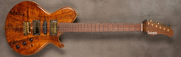 MODEL: LS-13 Guitar,
SERIAL: #7412,
FINISH: Natural,
BODY: Spruce Core with Koa top/back wood,
WEIGHT: 7.44 lbs,
NECK: Morado with thin matte nitro finish w/locking tuners,
FINGERBOARD: Brazilian Rosewood 12" radius, 1 3/4” nut width (US only),
PICKGUARD: none,
HARDWARE: Chrome with Tremolo Bridge,
PICKUPS: HSH,
PREAMP: Sadowsky preamp with vintage tone control