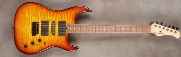 MODEL: Standard S-style,
SERIAL: #7425,
FINISH: Dark cherry burst,
BODY: Quilt maple on chambered alder,
WEIGHT: 6.71 lbs,
NECK: Maple with thin matte nitro finish,
FINGERBOARD: Morado, 12″ radius, 1.625″ nut width,
PICKGUARD: none,
HARDWARE: Black,
PICKUPS: Sadowsky H-S-H,
PREAMP: Sadowsky preamp with mid and mid/gain boost