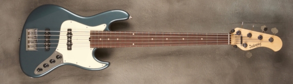 MODEL: 5-20 Vintage J-bass,
SERIAL: #7458,
FINISH: Vintage teal green metallic,
BODY: Chambered alder,
NECK: Maple with thin matte nitro finish,
FINGERBOARD: Madagascar rosewood, 12″ radius, 1.875″ nut width,
PICKGUARD: Mint,
HARDWARE: Chrome,
PICKUPS: Sadowsky hum-canceling in 70s locations,
PREAMP: Sadowsky preamp with vintage tone control