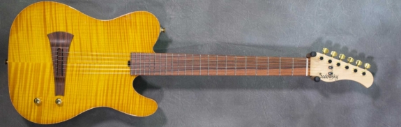 MODEL: Standard Electric Nylon,
SERIAL: #8743,
FINISH: Caramel Burst,
BODY: Chambered Alder with flame Maple Top,
WEIGHT: 5.92 lbs,
NECK: Maple with thin matte nitro finish,
FINGERBOARD: Morado, 12″ radius, 1 7/8″ nut width,
PICKGUARD: none,
HARDWARE: Gold,
PICKUPS: Barbera under-saddle,
PREAMP: Sadowsky buffer preamp