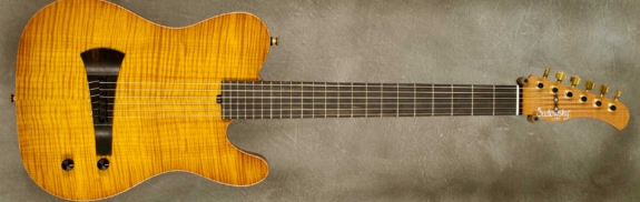 MODEL: Standard Electric Nylon,
SERIAL: #6165,
FINISH: Caramel Burst,
BODY: Chambered Okoume with Flame Maple Top,
WEIGHT: 5.76 lbs,
NECK: Maple with thin matte nitro finish,
FINGERBOARD: Morado, 12″ radius, 1 7/8″ nut width,
PICKGUARD: None,
HARDWARE: Gold,
PICKUPS: Barbera under-saddle,
PREAMP: Sadowsky buffer preamp